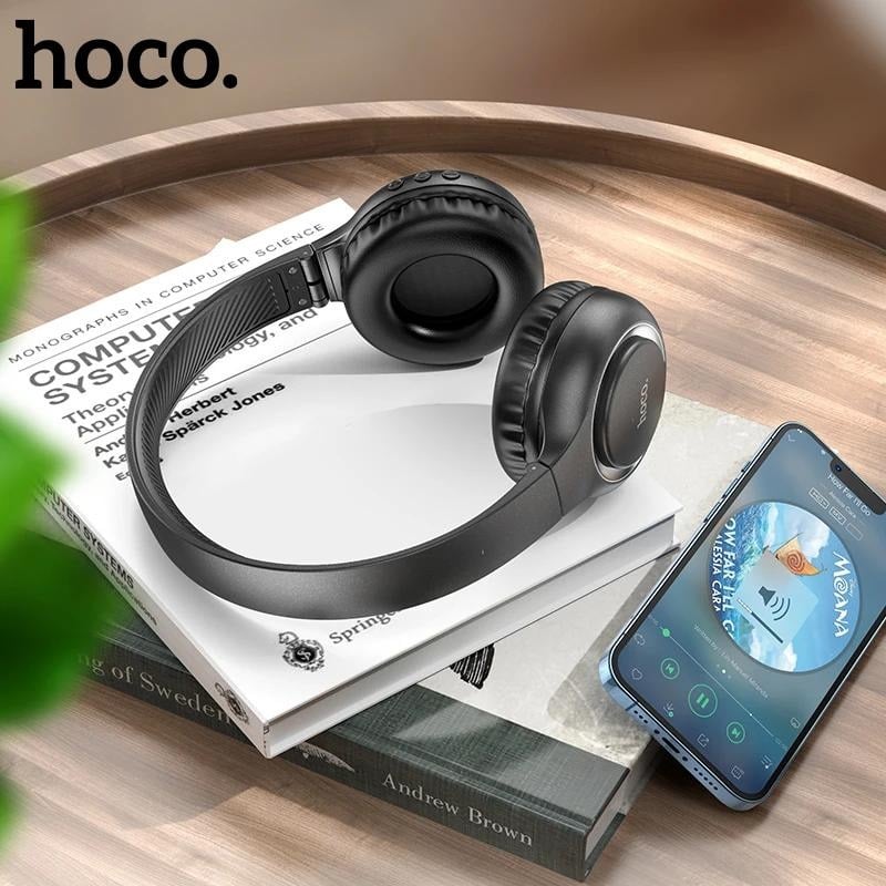 Audífonos de diadema HOCO W41 negros junto a un teléfono