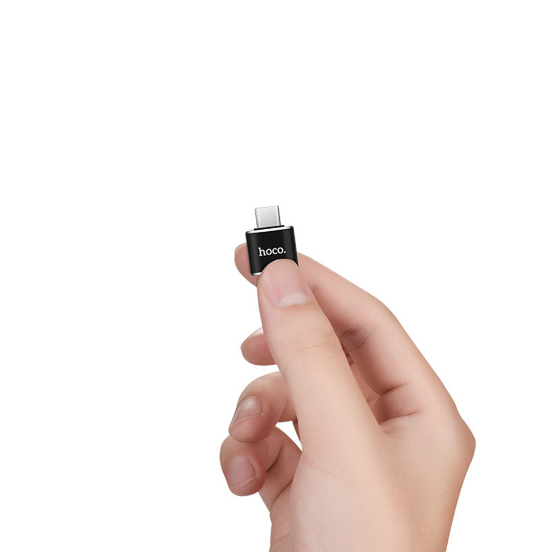 Adaptador HOCO UA5 en la mano mostrando su tamaño