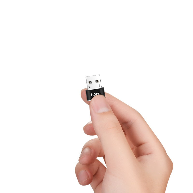 Adaptador HOCO UA6 en la mano mostrando su tamaño